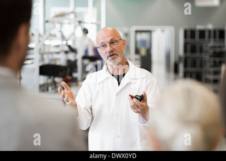 Ingegnere maschio discutendo con la gente di affari in impianto di produzione Foto Stock