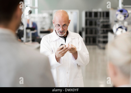 Ingegnere di macchina di spiegare alla gente di affari in impianto di produzione Foto Stock