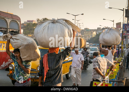 India Bengala Occidentale, Calcutta, gli uomini che trasportano merci sulla loro testa vicino alla stazione ferroviaria di Howrah Foto Stock