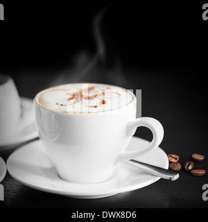 White tazza di cappuccino caldo su sfondo nero Foto Stock