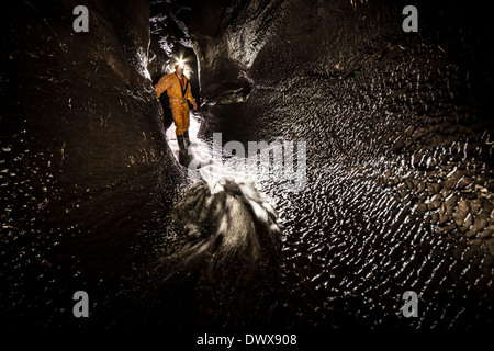 Un speleologo nel passaggio di flusso, Ogof Ffynnon Ddu, South Wales, Brecon Beacons, REGNO UNITO Foto Stock