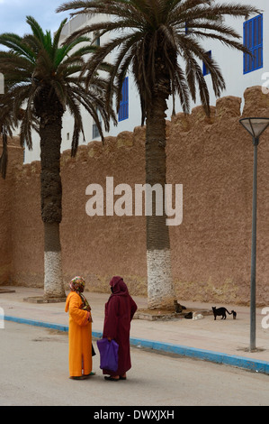 Due donne in abito tradizionale in chat sulle strade di essaouira marocco Foto Stock