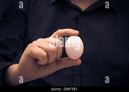 Uovo di gallina nella mano di un uomo Foto Stock