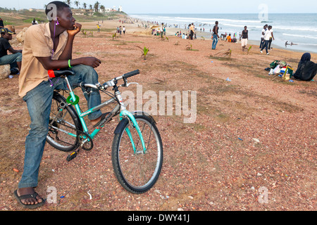 Ciclista sulla spiaggia, Accra, Ghana, Africa Foto Stock