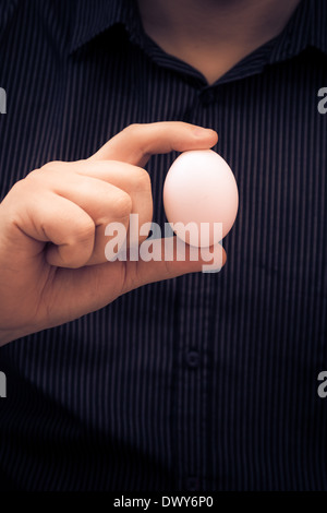 Uovo di gallina nella mano di un uomo Foto Stock