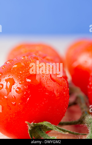 Close up di ciliegia matura, pomodori a grappolo su un tavolo con il cielo blu sullo sfondo Foto Stock