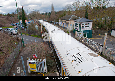 East Farleigh stazione ferroviaria con tradizionale traversata cancelli e signalbox con un treno su strada che attraversa Foto Stock