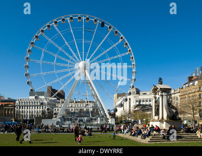 La ruota di Manchester Piccadilly Gardens, Manchester, Inghilterra, Regno Unito, con il memorial statua della regina Victoria sulla destra. Foto Stock