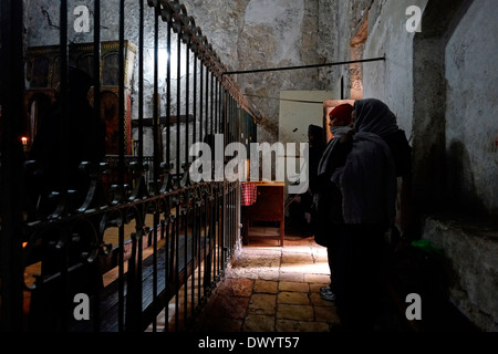 I cristiani ortodossi etiopi che pregano all'interno della Cappella Copta di San Michele Arcangelo nella parte inferiore della chiesa etiope nella parte inferiore della chiesa etiope sotto il monastero di Deir El-Sultan, che si trova sul tetto della chiesa del Santo Sepolcro nella città vecchia di Oriente Gerusalemme Israele Foto Stock