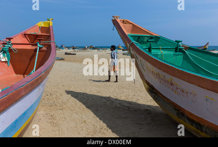 Barche da pesca stand ormeggiata sulla luminosa spiaggia sabbiosa di pescatori in stand by in attesa che la marea di girare in Mamallapuram, India. Foto Stock