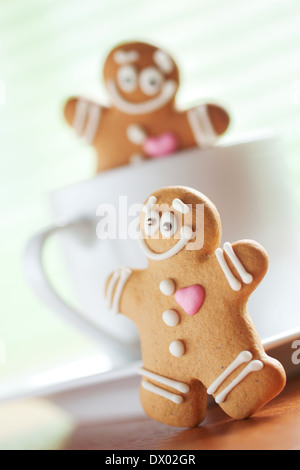 Funny gingerbread gli uomini giocano su una tazza Foto Stock