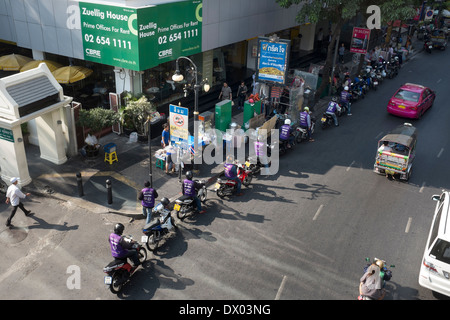 Moto linea di taxi in attesa di clienti sulla Silom Road nel centro cittadino di Bangkok Foto Stock