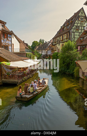 I turisti in barca in esecuzione attraverso il fiume Lauch a Colmar, Francia Foto Stock