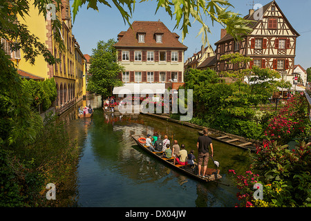 I turisti in barca in esecuzione attraverso il fiume Lauch a Colmar, Francia Foto Stock