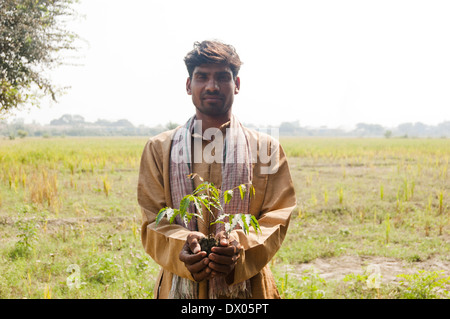 1 L'agricoltore indiano in piedi con impianto Foto Stock