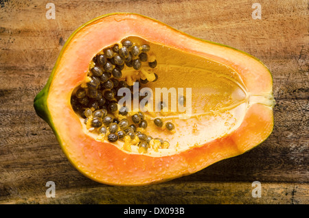 Top Shot di mezza papaia matura sul tagliere Foto Stock