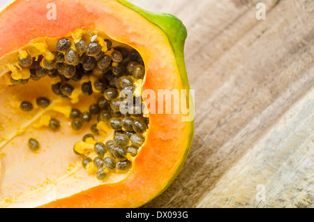 Top Shot di mezza papaia matura sul tagliere Foto Stock
