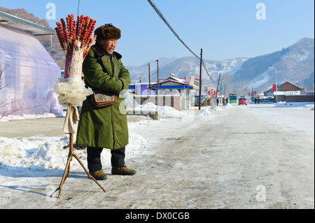 Venditore ambulante di vendita Tanghulu '' in attesa per i clienti nel periodo invernale . Provincia di Jilin, Cina. Foto Stock