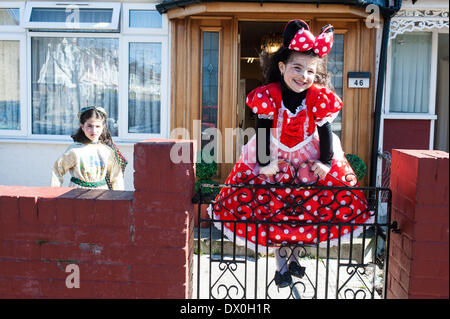 Londra, Regno Unito. Il 16 marzo 2014. Dassy, 10 (L) e Trany, 6 (R) celebrare la festa di Purim, ballare e cantare per le strade al suono della musica yiddish e visitando i ricchi commercianti per raccogliere per la loro carità Credito: Piero Cruciatti/Alamy Live News Foto Stock
