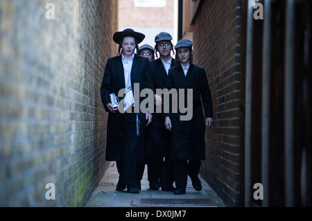 London, Regno Unito - 16 Marzo 2014 : Vestito in abiti di fantasia giovani provenienti da comunità ebrea ortodossa di Stamford Hill celebrare la festa di Purim, ballare e cantare per le strade al suono della musica yiddish e visitando i ricchi commercianti per raccogliere per la loro carità Foto Stock