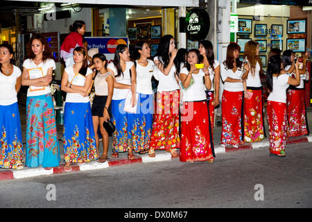 Massaggi Girls Watching una parata a Patong, Phuket, Tailandia Foto Stock