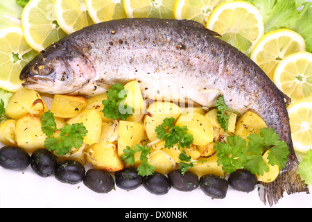 Tutta la trota iridea alla griglia con patate, limoni, olive Foto Stock