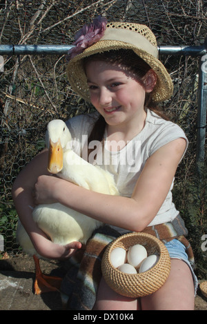 Giovane ragazza caucasica abbracciando il suo tame pet pekin anatra (Anas platyrhynchos domestica o Anas Pechino) , UK, Inghilterra Foto Stock