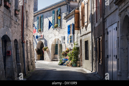 Scena di strada nel bellissimo villaggio di Montaigu de Quercy, Lot-et-Garonne, Midi-Pirenei, Francia: hotel cesti di fiori e flagse Foto Stock