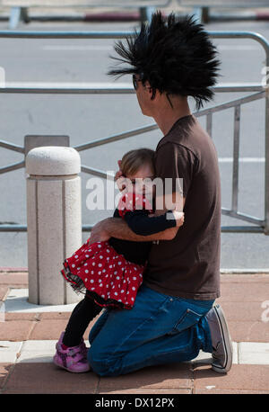 Holon, Israele. 16 marzo, 2014. Una ragazza israeliana avvolge il suo padre durante Adloyada Holon Purim Parade 2014 in Holon, Israele centrale, il 16 marzo 2014. Purim, celebrato quest anno dal tramonto, 15 marzo al calar della sera, 16 marzo è una festa ebraica che commemora la liberazione del popolo ebraico in persiano antico impero in cui un appezzamento è stata formata per distruggerli. Credito: Xinhua/Alamy Live News Foto Stock