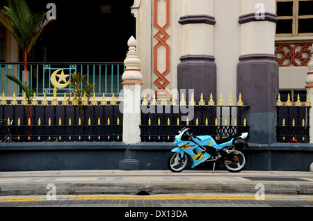 Blue giallo sportivo moto parcheggiata sul marciapiede fuori la Moschea del Sultano Kampong Glam Singapore Foto Stock