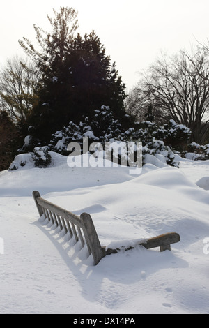 Una panchina nel parco coperto di neve. Foto Stock