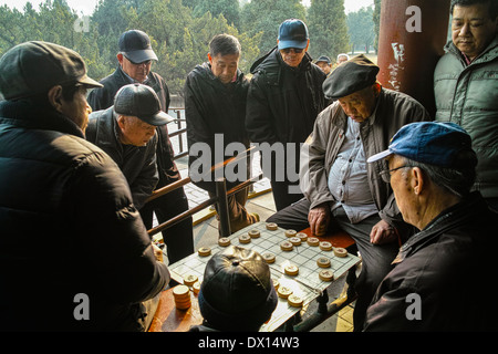 Due uomini scacchi cinesi e gli altri a guardare nel lungo corridoio e il Tempio del Paradiso Foto Stock