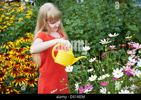 Bambina fiori di irrigazione in giardino Foto Stock