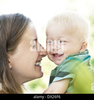 Ridendo madre con bambino in giardino Foto Stock