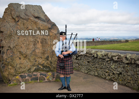 Un uomo suonare la sua cornamusa intrattenere i visitatori al valico di frontiera tra Scozia e Inghilterra al carter Bar nelle vicinanze Jedburgh Foto Stock