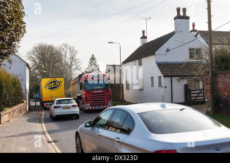 Il traffico pesante che passa da una casa su una strada trafficata nel piccolo borgo rurale di Rempstone, Nottinghamshire, England, Regno Unito Foto Stock