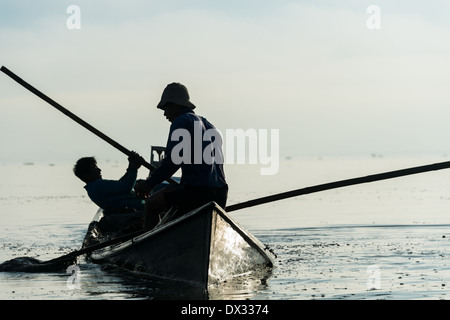 Lago Inle, MYANMAR - CIRCA NEL DICEMBRE 2013: uomo raccogliendo il fango e le erbacce dal fondo del lago per costruire i giardini galleggianti nel Lago Inle. Foto Stock