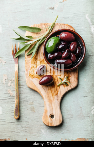 Olive con foglie di salvia su sfondo di legno Foto Stock