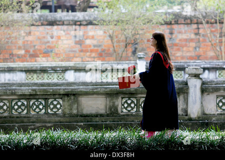 Studente laureato presso l'università Vietnamite festeggiare in occasione di una cerimonia che si è svolta presso il Tempio della Letteratura. Hanoi, Vietnam Foto Stock