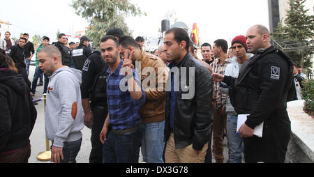 Ramallah, West Bank, Palestina - Marzo 17, 2014: i palestinesi a piedi prima di essere immessa all'interno del Grand Park Hotel a Ramallah inizio lunedì mattina Marzo 17, 2014 per audition per la terza stagione di idolo arabo talent show dal gruppo MBC. Tali audizioni sono tenuti per la prima volta nella città di Ramallah dopo la cantante palestinese Mohammed Assaf ha vinto l'Idolo arabo award a Beirut, Libano, giugno 2013. Assaf divenne il primo palestinese a conquistare il mondo arabo la versione di American Idol. Credito: Abdalkarim Museitef/Pacific Press/Alamy Live News Foto Stock