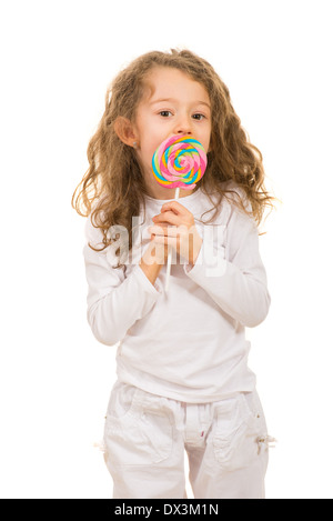 Ragazza leccare un gustoso lollipop isolati su sfondo bianco Foto Stock