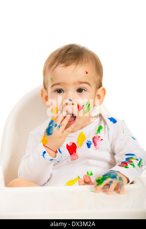 Bambino bello con vernici su viso e mani tenendo la mano alla bocca isolati su sfondo bianco Foto Stock