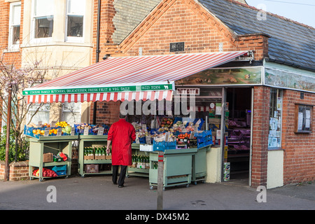 Negozio tradizionale keeper al di fuori del suo angolo shop in Cambridge, Inghilterra Foto Stock