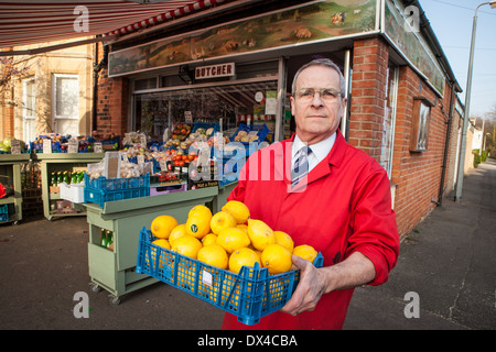 Negozio tradizionale keeper al di fuori del suo angolo shop in Cambridge, Inghilterra Foto Stock