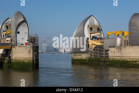 Una vista di Canary Wharf e l'Arena O2 attraverso due pontoni della Thames Barrier. Foto Stock