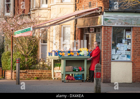 Negozio tradizionale keeper al di fuori del suo angolo shop in Cambridge, Inghilterra Foto Stock