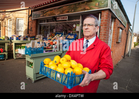 Negozio tradizionale keeper al di fuori del suo angolo shop in Cambridge, Inghilterra Foto Stock