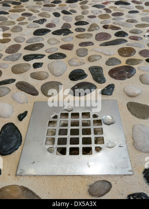 Scarico in pietra di fiume doccia piastrellata pavimento Foto Stock