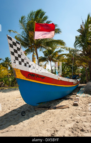 Sud Sud dell India Kerala Alleppy Mararikulam spiaggia barca da pesca in legno sabbia shore surf mare sun blue sky scenario di scena Foto Stock