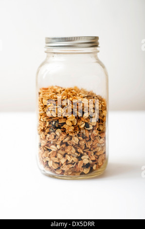 Ancora vita immagine di un vasetto di vetro contenenti fatti in casa, senza glutine granola isolato su uno sfondo bianco Foto Stock